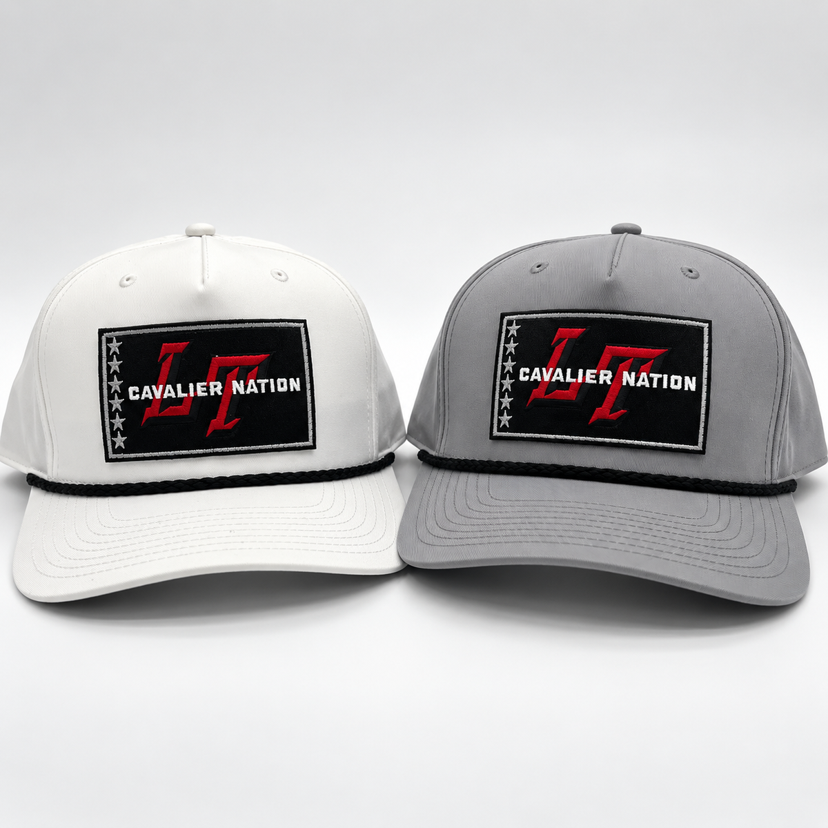 Two Lake Travis trucker snapback hats side by side on a light gray studio background. The left cap is white with a black embroidered patch reading "CAVALIER NATION" and red "LT" lettering.
